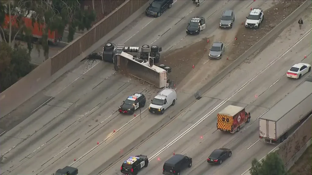 Overturned truck spills load of dirt onto 605 Freeway in Whittier